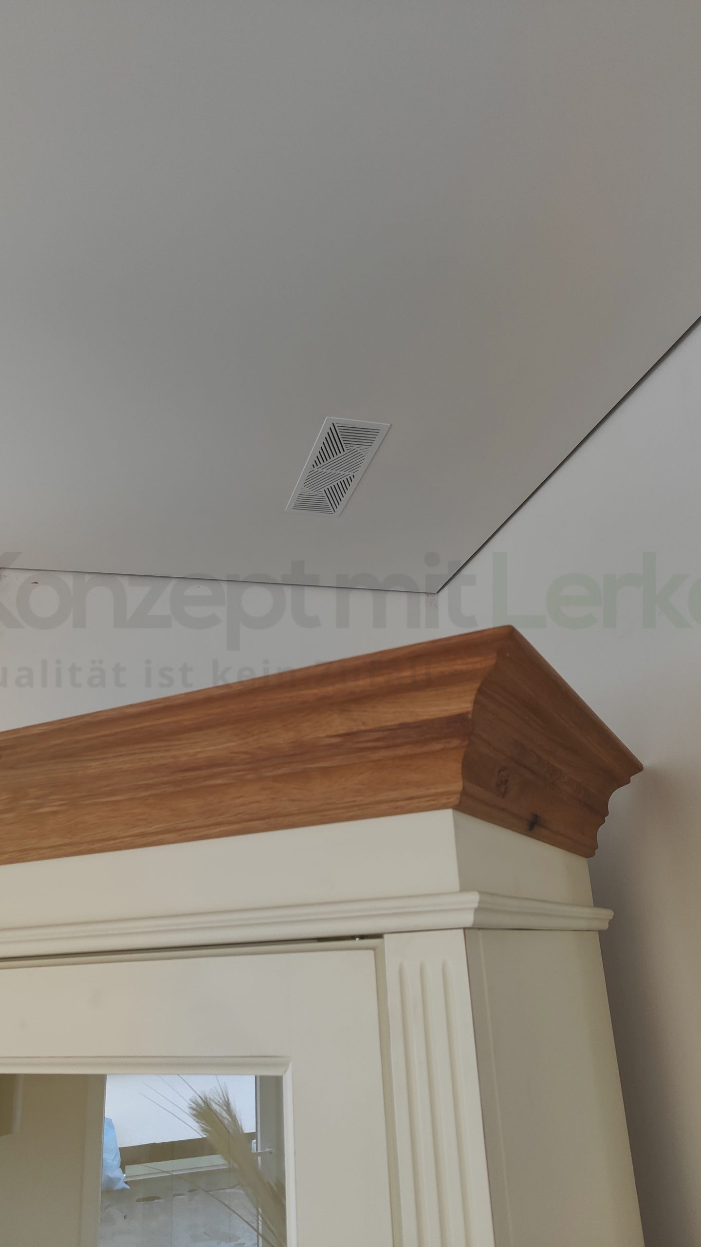 Weiße Spanndecke mit umlaufender Schattenfuge und Revisionsgitter zur Einstellung der Pendelleuchten.
