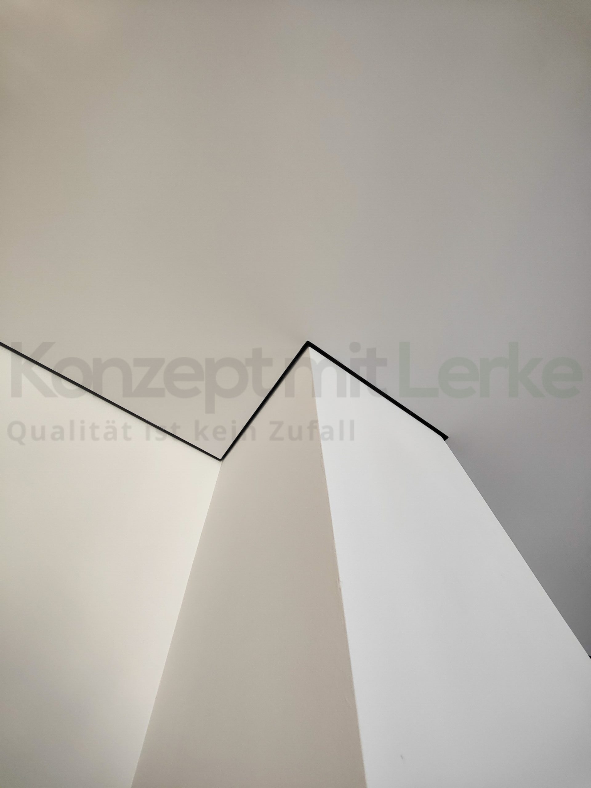 Weiße textile Spanndecke von PONGS mit schwarzer Schattenfuge entlang einer verwinkelten Wand- und Deckengeometrie.
